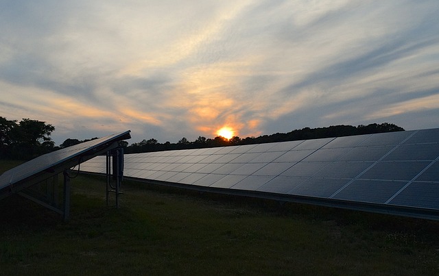 ground mounted solar panel array next to industrial warehouse facility
